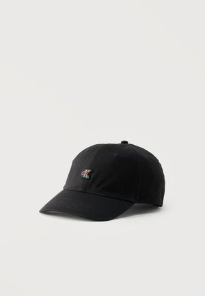 Casquette de baseball noire à visière courbée avec un petit logo "CK" multicolore à l'avant, sur un fond blanc uni.