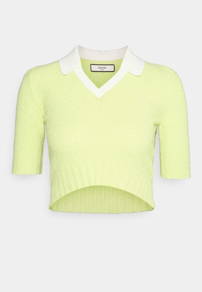 Suéter cortado de um vibrante verde limão, feito de material texturizado. Apresenta um colarinho branco e plano, e mangas curtas com uma bainha canelada.