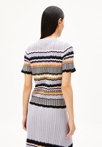 Strickoberteil mit horizontalen Streifen in Pastellfarben und schwarzen sowie grauen Akzenten. Kurze Ärmel, gerippte Textur und gewellte Kanten.