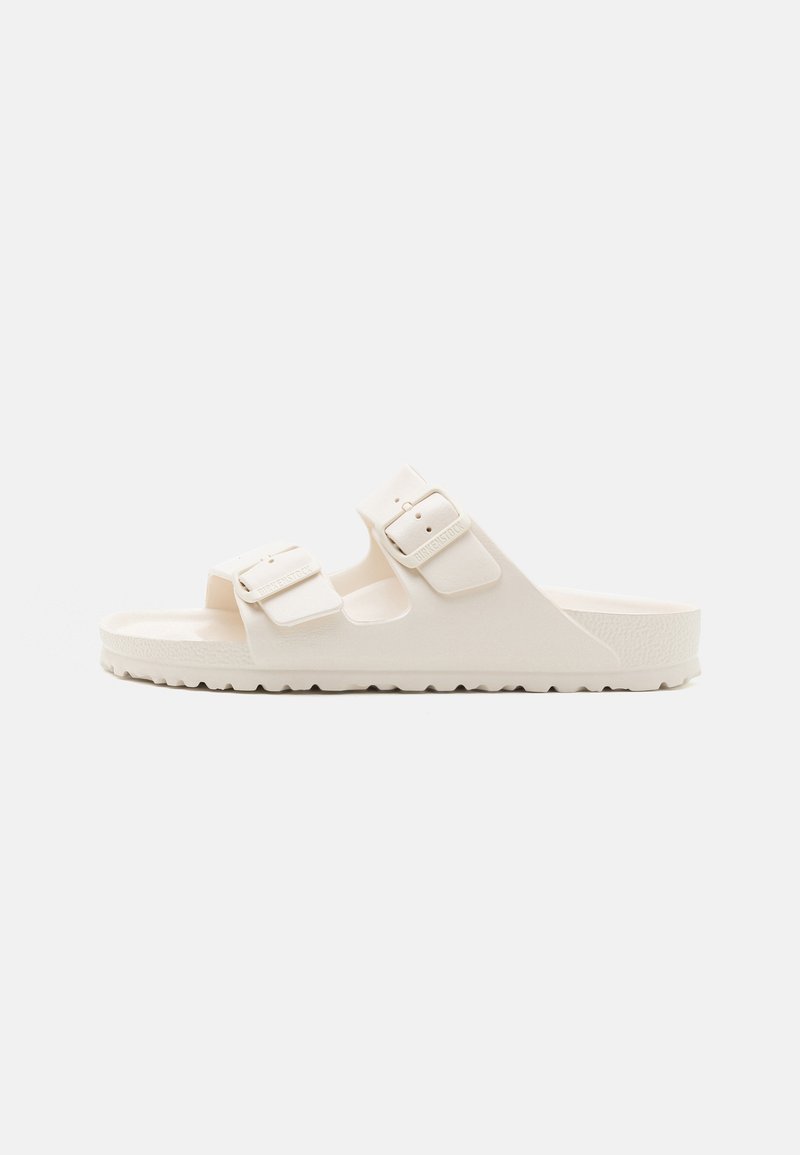 Sandal bianca a due cinghie realizzata in materiale resistente, dotata di fibbie regolabili, suola testurizzata e una suola spessa e sagomata con scanalature.