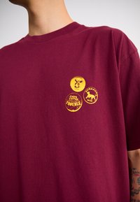 Carhartt WIP PINS - Printtipaita - malbec/orange stone washed