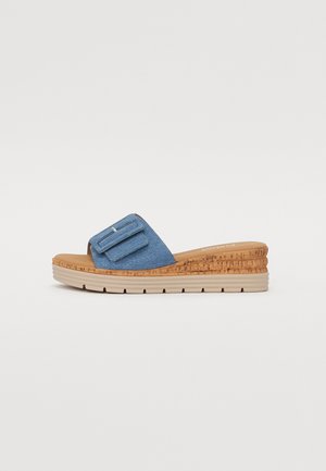 Sandalo in denim blu con suola in sughero a zeppa, dotato di una fascia larga con dettaglio fibbia e una base testurizzata a più strati.