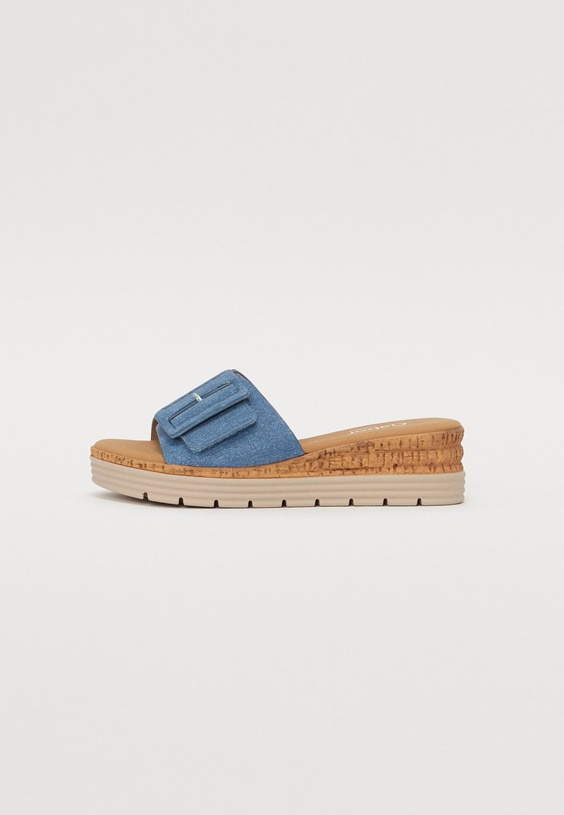 Blue denim slide sandal with a cork wedge sole, featuring a wide strap with a buckle detail and a textured, multi-layered base.