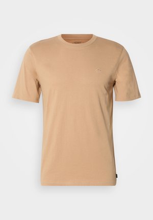 T-shirt en coton brun clair avec des manches courtes, un col rond et un petit logo sur la poitrine gauche. Texture douce et coupe standard.