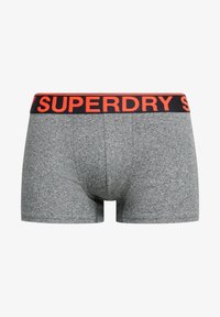 Szare bokserki z teksturowanej tkaniny, z czarnym pasem z napisem "SUPERDRY" w jasnopomarańczowym kolorze.