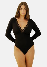 Body noir à manches longues avec un décolleté en V profond orné de dentelle, en tissu lisse, et un design à jambe haute pour une silhouette ajustée.