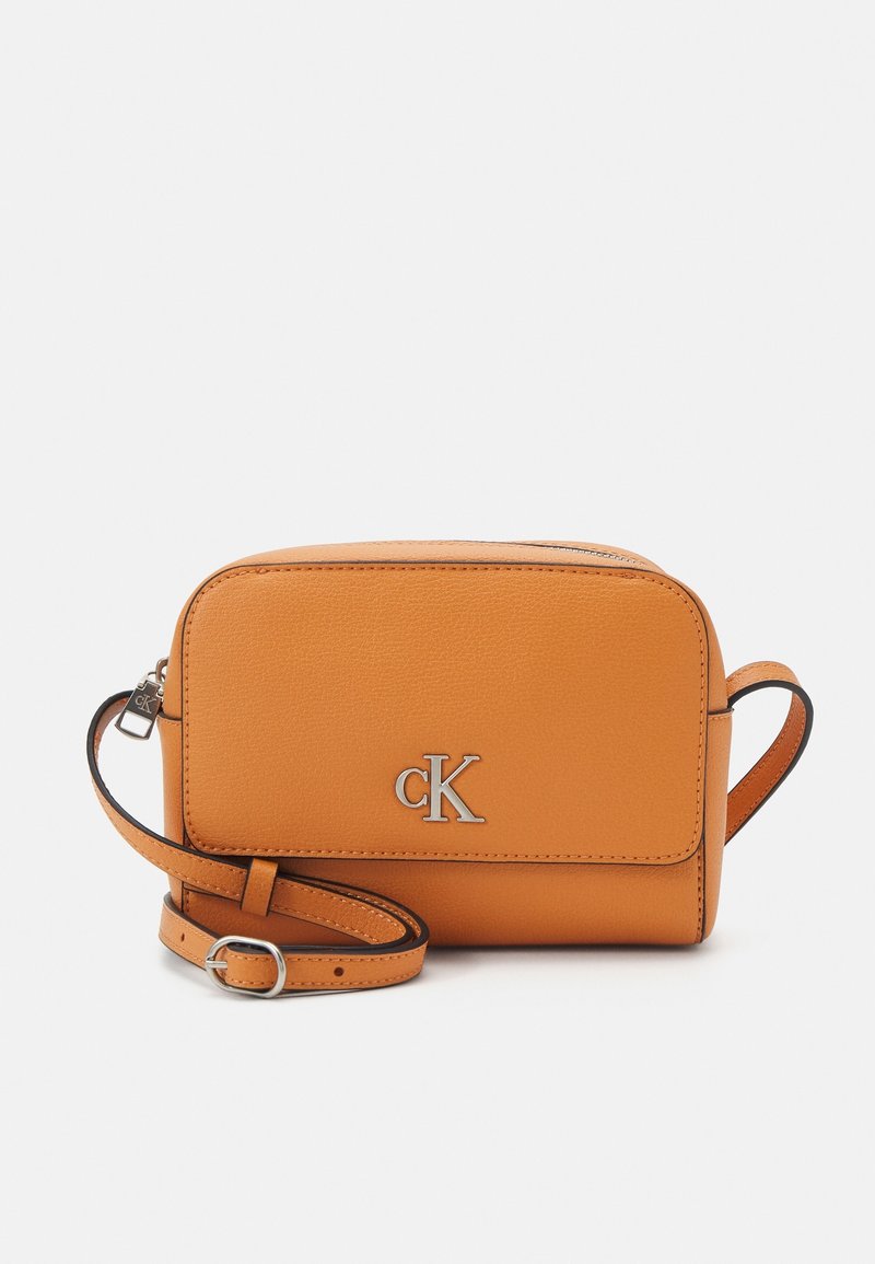 Calvin Klein orange leather crossbody bag with a rectangular shape, zip closure, and adjustable strap. Silver "CK" logo on front.