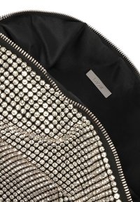 Svart zip-påse med en metallisk rhinestone-yta, en slät svart tyginsida och en silverfärgad varumärkesetikett.