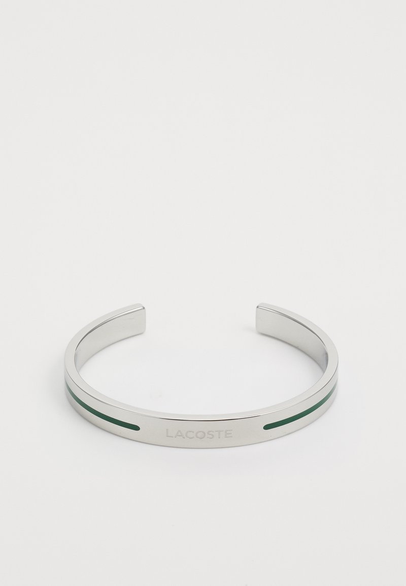 Ατσάλινη βραχιόλι σε ασημί απόχρωση με πράσινη ανασημείωση, σκαλισμένη με το 'LACOSTE.' Λείος υφής, ανοιχτό σχέδιο και στα δύο άκρα.