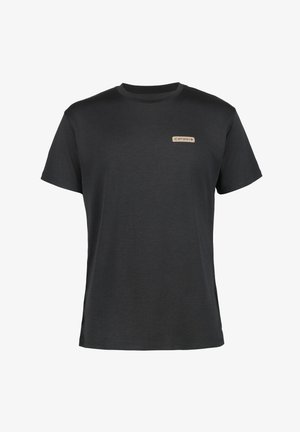 Camiseta negra de manga corta con escote redondo y un pequeño parche de logo claro en el lado izquierdo. Textura suave, ajuste casual.