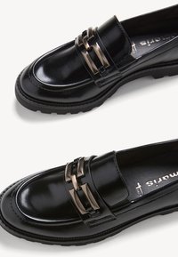 Zwarte leren loafers met een glanzende afwerking, voorzien van een dubbele metalen gesp en een gestructureerde rubberen zool. Klassiek ontwerp en vorm.