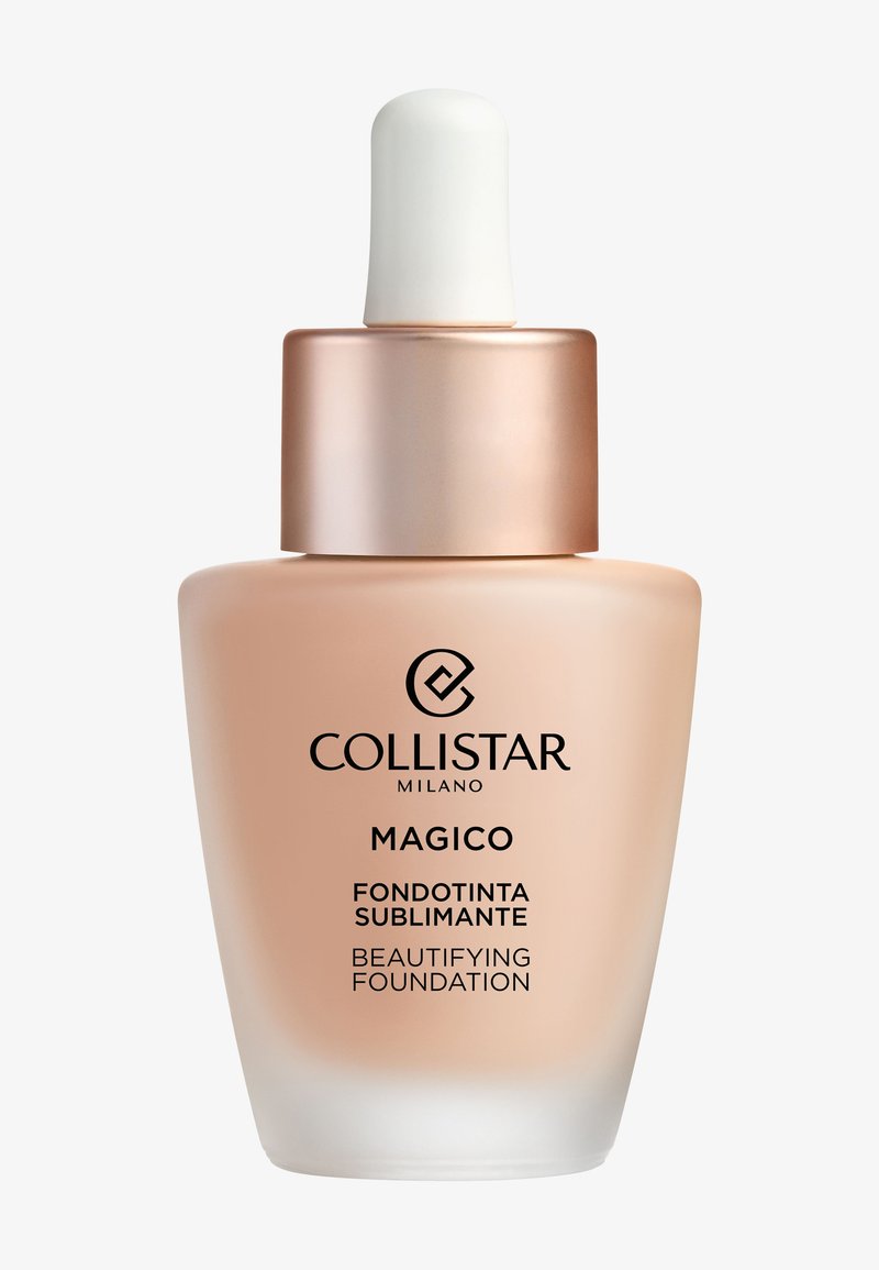 Bottiglia goccia in vetro beige con tappo color oro rosa. L'etichetta mostra "Collistar Milano Magico Beautifying Foundation." Texture liscia, design minimalista.