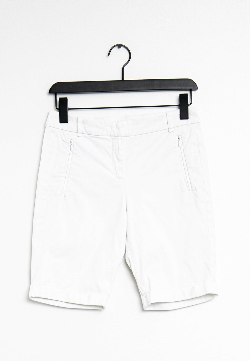 Shorts blancs en tissu léger, dotés de deux poches latérales zippées, d'un ourlet roulé et d'une texture lisse. Accrochés à un cintre noir.