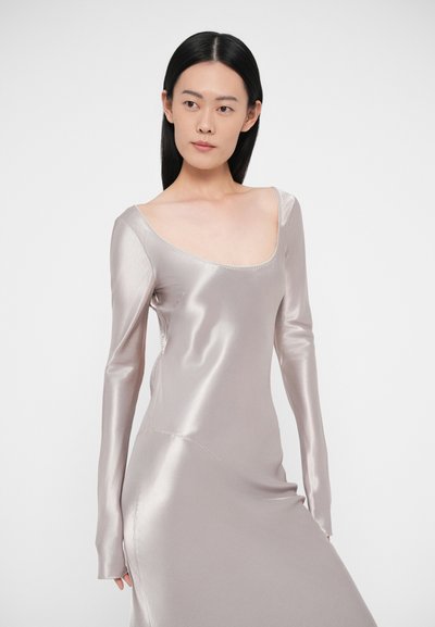 Dlhé saténové šaty s dlhým rukávom v svetlosivej farbe s mierne hlbokým okrúhlym výstrihom. Hladká textúra a priliehavý strih. Dekoratívne prešívanie pozdĺž švov.