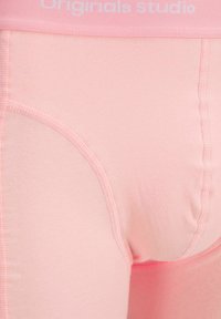 Helle rosa Boxershorts aus dehnbarem Material, mit einem weichen Bund und genähten Details entlang der Kanten.
