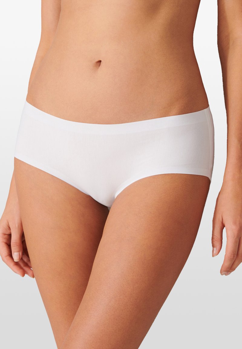 Culottes hipster blanches en tissu doux et lisse, avec un design élégant et sans coutures, et une taille élastique pour un ajustement confortable.