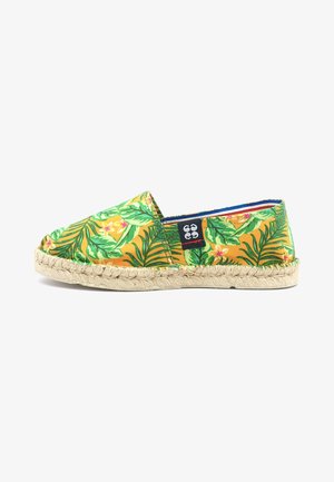 Chaussure espadrille jaune ornée de motifs de feuilles tropicales vertes et de fleurs, avec une semelle en corde de jute et une doublure bleue.