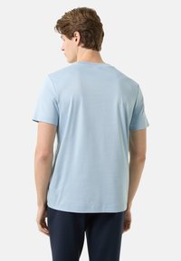 Světle modré bavlněné tričko s krátkými rukávy, kulatým výstřihem a hladkou texturou. Jednoduchý design bez vzorů či viditelných log.