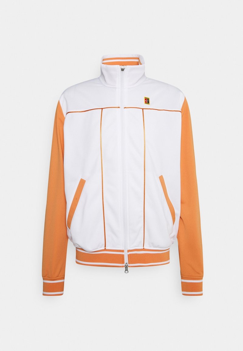 Chaqueta deportiva de cremallera blanca y naranja, con un alto cuello, bolsillos laterales, puños de canalé y detalles de piping en contraste.