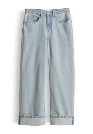 Lichtblauwe denim jeans met wijde pijpen, omgeslagen zomen, voor- en muntenzakken, lussen voor een riem en een knoopsluiting op een witte achtergrond.