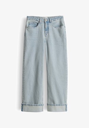 Lichtblauwe denim jeans met wijde pijpen, omgeslagen zomen, voor- en muntenzakken, lussen voor een riem en een knoopsluiting op een witte achtergrond.