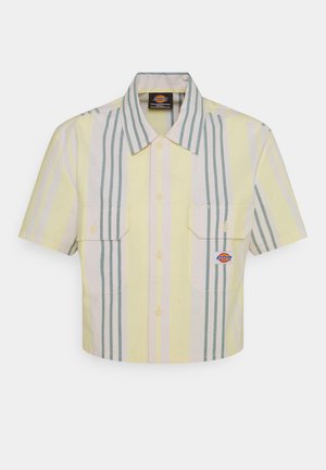 Lühikeste varrukatega lühendatud särk heledas kollases, millel on vertikaalsed rohelised ja pastelltriibud. Sellel on kaks rinna taskut ja logo silt vasakul taskul.