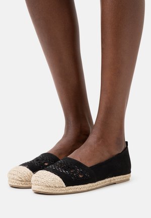 Espadrilles noires avec une semelle en jute tressé, présentant une tige en tissu noir texturé avec des découpes et un embout rond.
