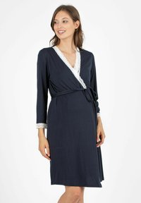 Abito avvolgente blu navy con maniche lunghe, bordatura in pizzo sul collo e sulle maniche, e una cintura legata in vita. Tessuto morbido e vestibilità rilassata.