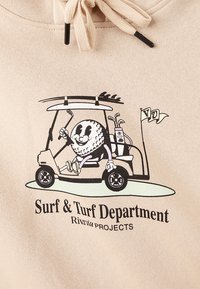 Beige hoodie featuring a printed graphic of a cartoon character driving a golf cart, labeled "Surf & Turf Department."