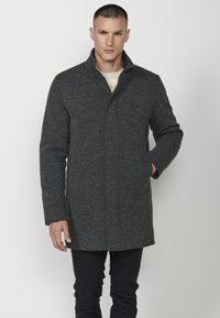 Abrigo gris oscuro con cuello alto, mangas largas y corte recto. Presenta bolsillos frontales y una tela texturizada. Diseño sencillo.
