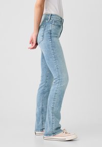 Lichtblauwe denim flare jeans met een hoge taille, voorzien van een ontwerp met vijf zakken en subtiele wassing, aangevuld met een gladde textuur.