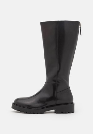 Knæhøj sort læderstøvle med en glat finish, chunky gummisål og en sidelukning for nem påtagning. Har minimalistisk design.
