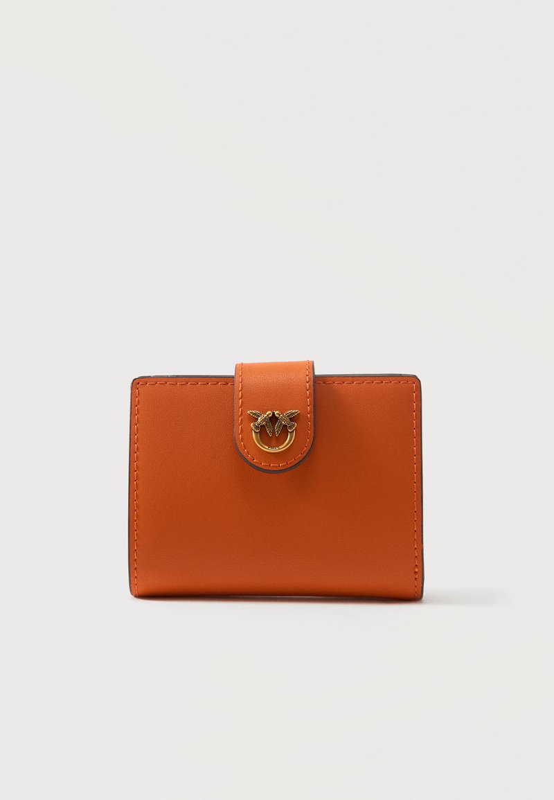 Πορτοφόλι από πορτοκαλί δέρμα με κλείσιμο με ταμπ που διαθέτει χρυσό διπλό έμβλημα πουλιού, απεικονισμένο σε απλό λευκό φόντο.