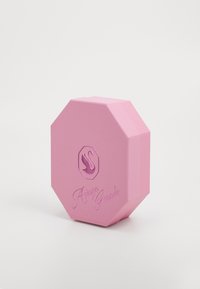 Roosa oktagonaalne parfüümikarp, millel on tekstureeritud pind, silmapaistva luige logoga ning nime "Ariana Grande" kalligraafilises fondis.