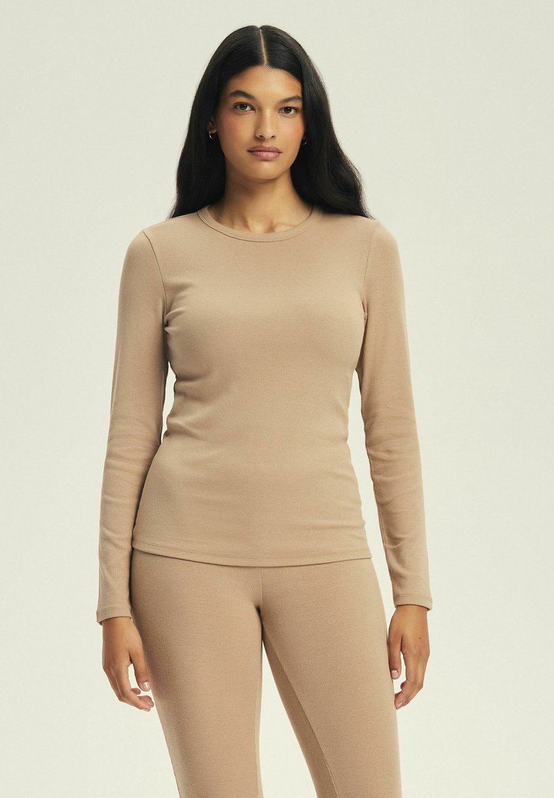 Jasno beżowy, długi rękaw, prążkowany top wykonany z miękkiego materiału, z okrągłym dekoltem, w zestawie z dopasowanymi prążkowanymi spodniami; dopasowany krój.