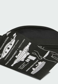 Black fabric bag with white graphics, featuring a compression system, main compartment, and inner mesh pocket for storage and organization.