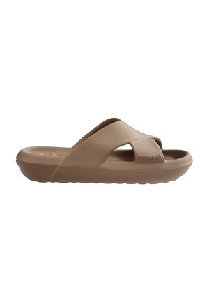 Bruine slip-on sandaal met dikke zool en brede kruisbanden, met een gestructureerd voetbed en de merknaam gegraveerd aan de zijkant.