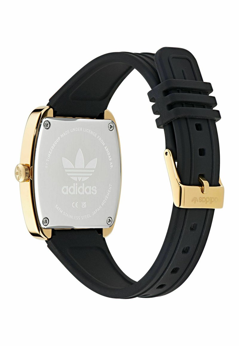 Adidas-Armbanduhr mit quadratischem goldfarbenem Gehäuse, schwarzem Silikonarmband und graviertem Edelstahlrückenteil mit Markenlogo und Details an der Schnalle.