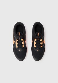 Baskets de sport noires avec des accents orange, dotées d'un dessus en mesh, d'un bout arrondi et d'un design à lacets. Logo NIKF sur le côté et la languette.