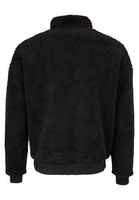 Crna fleece jakna s teksturiranom, mekanom površinom, visokim ovratnikom te rebrastim manžetama i rubom. Jednostavan dizajn, bez vidljivih metalnih dijelova ili uzoraka.