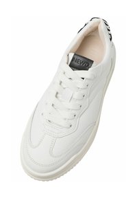 Baskets blanches avec un dessus en cuir lisse, bout rond, accent en cuir noir au talon, lacets blancs plats et détails de couture subtils.