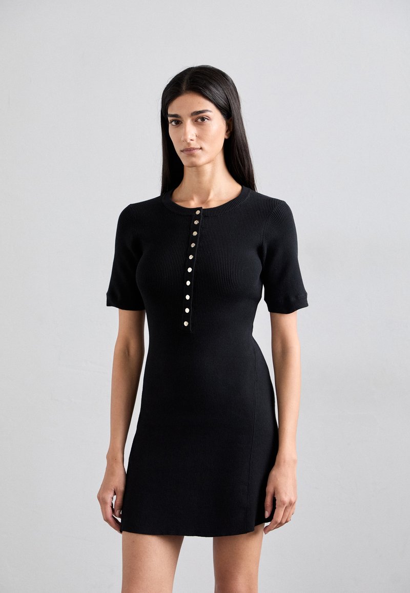 Black ribbed dress with short sleeves, featuring a crew neckline and a row of metallic buttons down the front. Smooth texture, fitted shape.