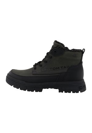Botte d'hiver montante vert foncé et noire avec semelle épaisse, lacets à l'avant et doublure douce en fourrure autour de la cheville, marquée sur le côté avec "Tom Tailor".