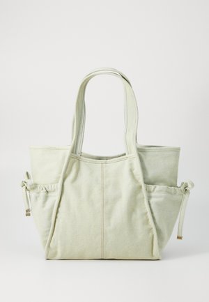 Canvas-Shopper in Hellgrün, mit zwei langen Trägern, Seitentaschen mit Kordelzugverschluss und sichtbaren Nähten.