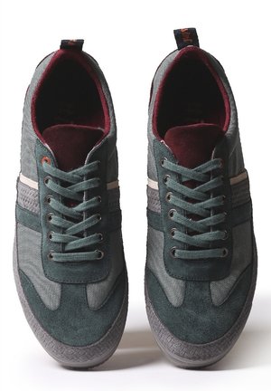 Paar dunkelgrüne und graue Schnürsneaker mit strukturierten Sohlen und bordeauxfarbenem Innenfutter, von oben auf weißem Hintergrund betrachtet.