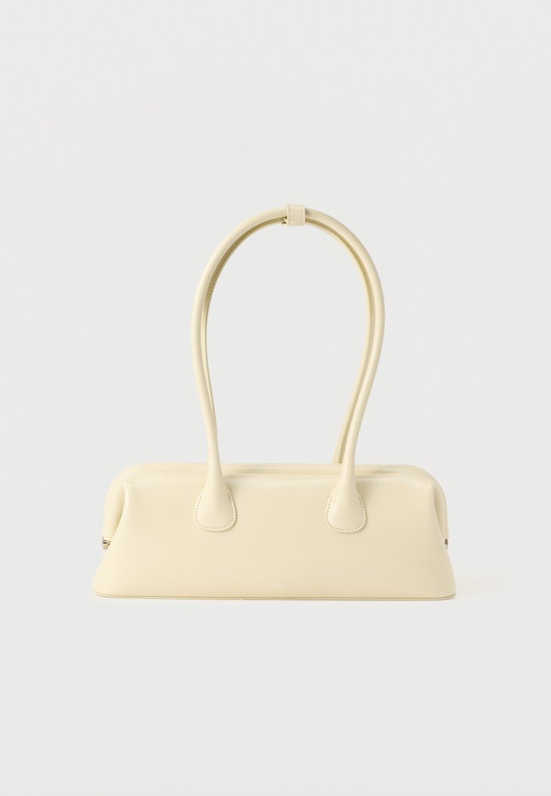 Pravokotna kremno obarvana torbica z zaobljenimi robovi in dvema dolgima, ukrivljenima ročajema, prikazana na belem ozadju.