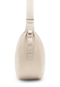 Béžová textilná taška s zaobleným tvarom, nastaviteľným popruhom a nariasením na spodnej časti. Kovové doplnky sú minimalistické a funkčné.