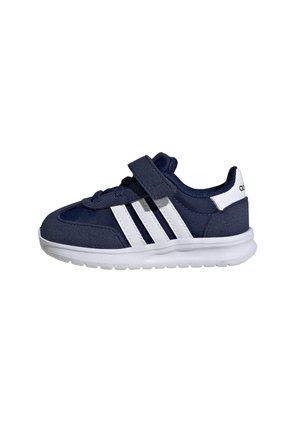 Zapatilla deportiva azul marino con acentos blancos, parte superior de tela, correa de Velcro y tres franjas blancas en el lateral. Suela acolchada para mayor comodidad.