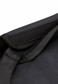 Zwart nylon stof met een gestructureerde afwerking, voorzien van gestikte randen, een hengsel en een klittenbandsluiting aan de bovenkant.