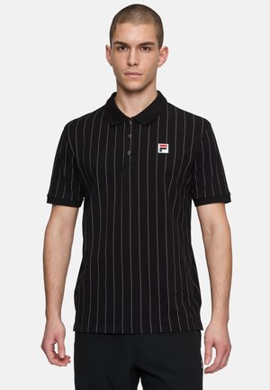 Schwarzes Polohemd mit dünnen vertikalen weißen Streifen, kurzen Ärmeln und einem Kragen. Verfügt über ein kleines gesticktes Logo auf der linken Brust.